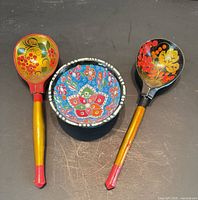 Front view of two painted wooden spoons and ceramic bowl