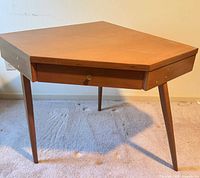 Front view of corner accent table showing drawer and three legs