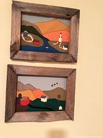 Both framed textile artworks on wall showing full view