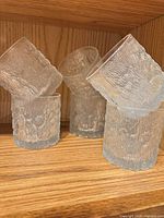 Five of the seven clear textured tumblers upright and angled to show exterior pattern