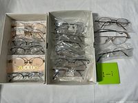 Two boxes of eyeglasses plus two loose pairs shown