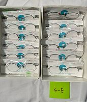 Two open boxes showing 16 packaged eyeglass frames