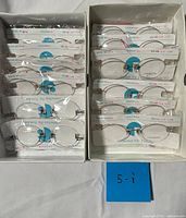 Two boxes containing individually wrapped rimless eyeglass frames