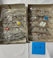 Two boxes with ten individually bagged eyeglass frames and blue tag