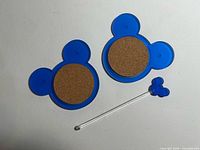 Front view of two Mickey coasters and stirrer