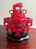 Front view of carved cherry amber censer on stand