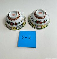 Upside-down view showing base stamps and exterior decoration of both bowls