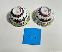 Bottom view showing red backstamp and exterior design of both bowls