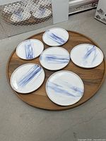 Six plates arranged on round wooden tray
