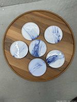 Top view of six blue brushstroke plates on wooden tray