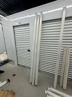 Seven long white linear fixtures leaning against storage unit door