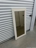 Front view of rectangular mirror leaning against wall