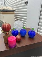 Group shot of glass apples, candles, vase and stand