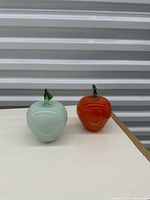 Two glass apple figurines side by side