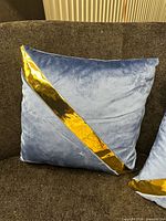 Front view of blue velvet pillow with gold band