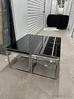 Rectangular coffee table with two square bases beneath tinted black glass top