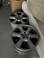 Two of the Volvo alloy rims stacked, showing spoke design and center caps