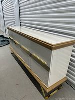Front and side view of white MDF console with wood accents and gold pulls