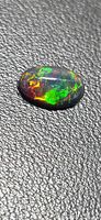 Top view of oval Ethiopian black opal showing multicolour fire