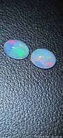 Two oval cabochon opals showing red and green flashes