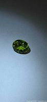 Oval apple-green peridot on neutral background