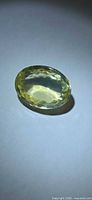 Front view of faceted oval lemon citrine on neutral background
