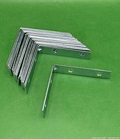 Stack of 20 zinc corner braces forming an angled bundle
