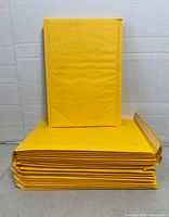 Stack of yellow padded mailers, showing exterior size and quantity