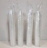 Four sealed sleeves of stacked clear plastic measuring cups