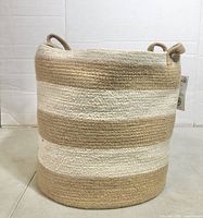 Front view of striped jute basket showing height, pattern and handles