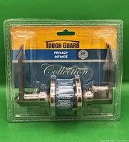 Front view of sealed Tough Guard privacy lever handle set showing pewter finish handles in packaging