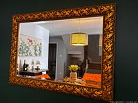 Front view of ornate gold framed mirror reflecting room