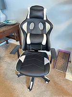 Front view of black and white PU leather racing gaming chair with lumbar pillow