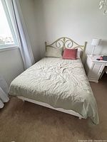Assembled bed showing headboard, mattress, bedding
