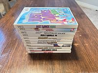 Stack of 10 Wii game cases showing titles on spines