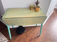 Table front view with leaves down showing painted top, turned legs