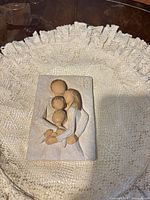 Front view of sculpted ceramic wall plaque showing family relief design