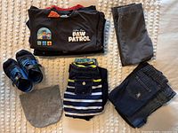 Overview of folded shirts, pants, sneakers, beanie and swim trunks