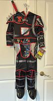 Front view of full ninja costume with attached accessories and sword