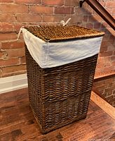 front angle of wicker hamper with lid closed and liner visible