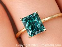 Ring on finger showing overall design and blue stone