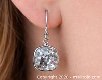 Earring worn, showing size and drop style with cushion-cut stone