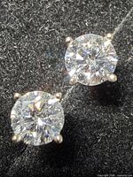 Close-up of both earrings showing gemstones and prong settings