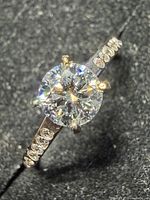 Top view of ring showing round center lab diamond and CZ-accented band