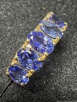 Top view showing five oval stones set in yellow gold