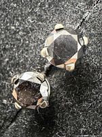 Front view of both black diamond studs in prong settings