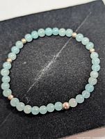 Bracelet laid flat showing full strand of amazonite beads with metal spacers