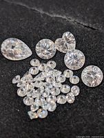 Assorted loose cubic zirconia stones on black background