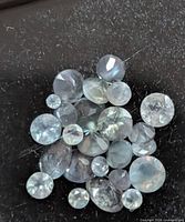 Cluster of loose round faceted alexandrite stones on dark background