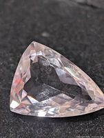 Trillion-cut faceted amethyst on dark background